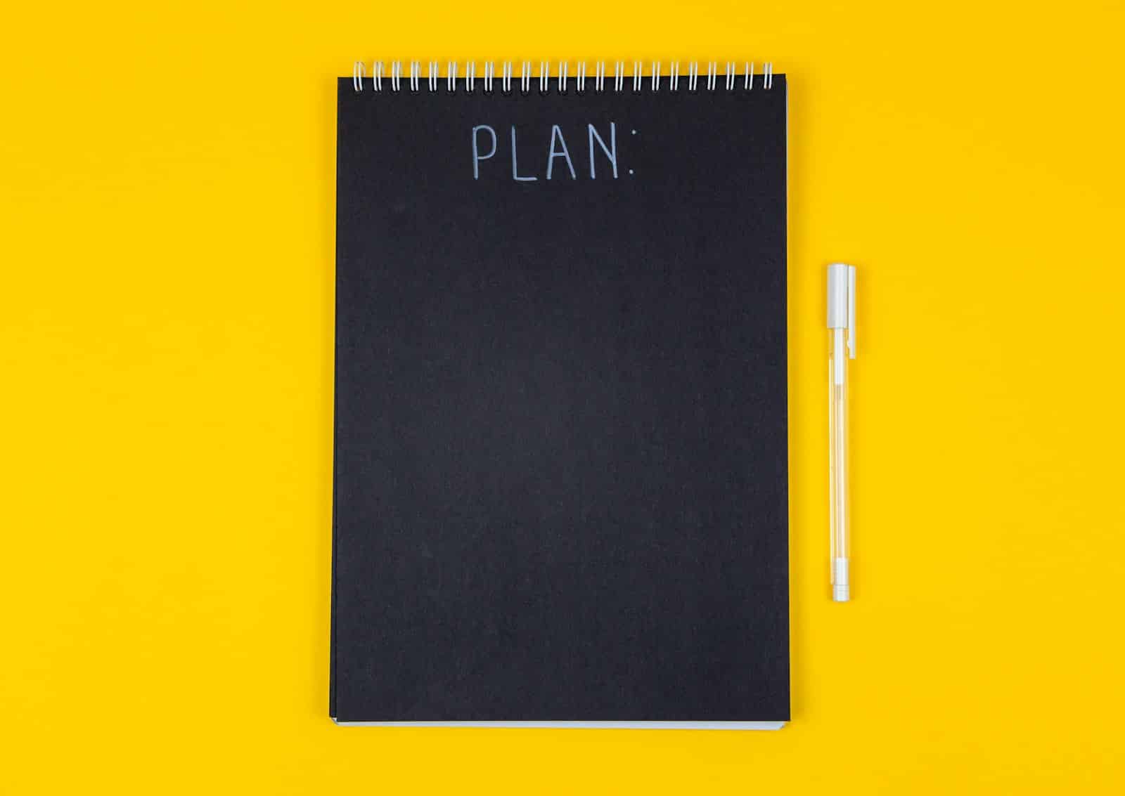 Notitieboek met een uitgewerkt plan op een bureau