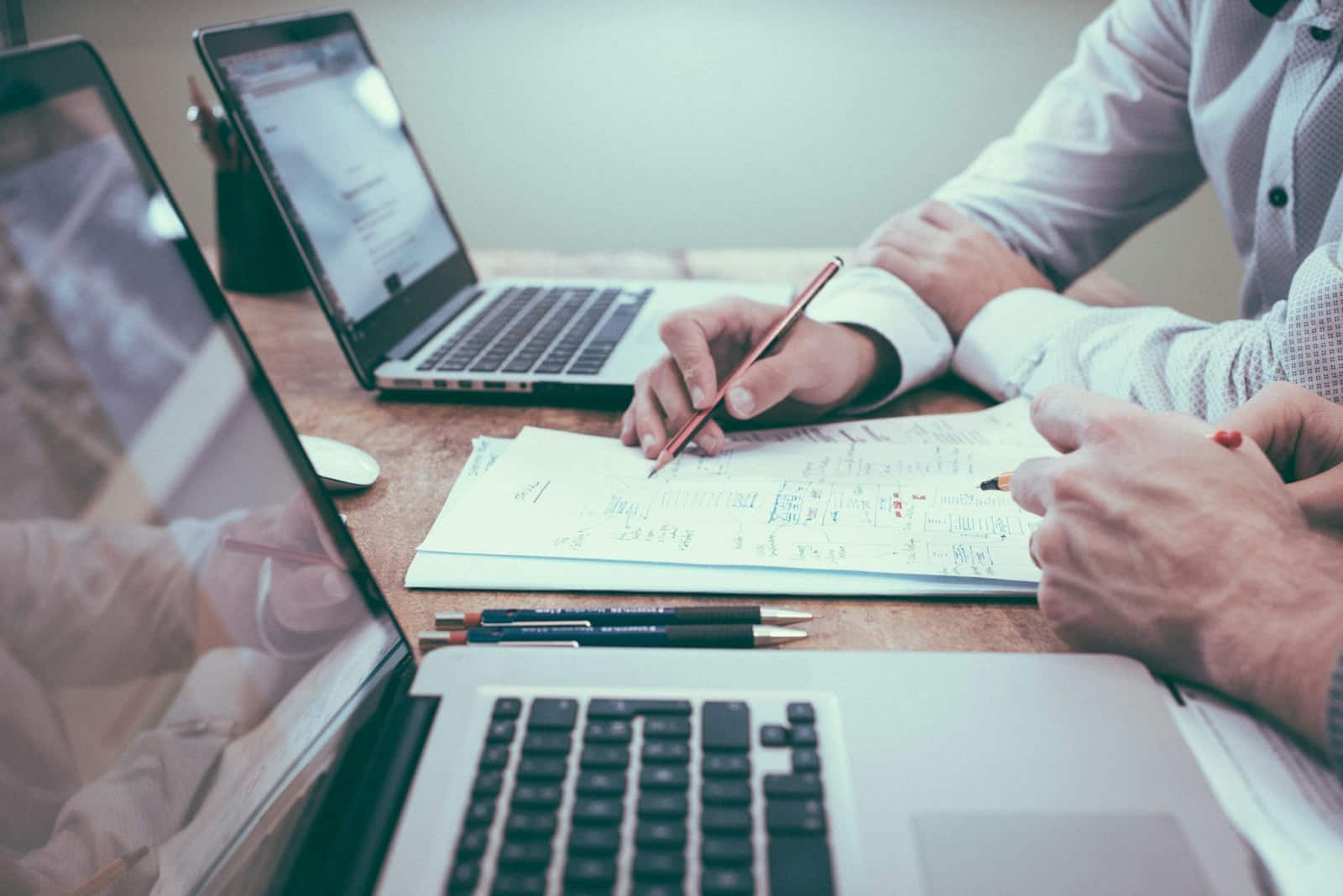 Twee mensen overleggen over een planning op een laptop